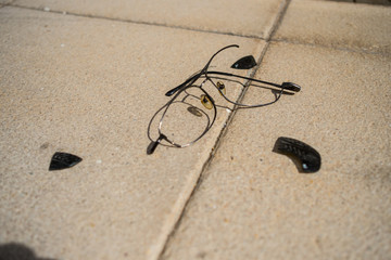  close-up of a broken and pulled sunglasses on a street