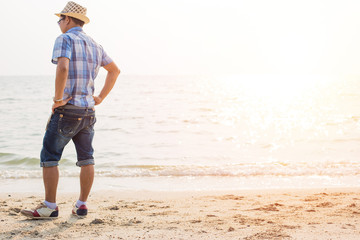 The man stand on the beach..the business wear hat and relaxing.