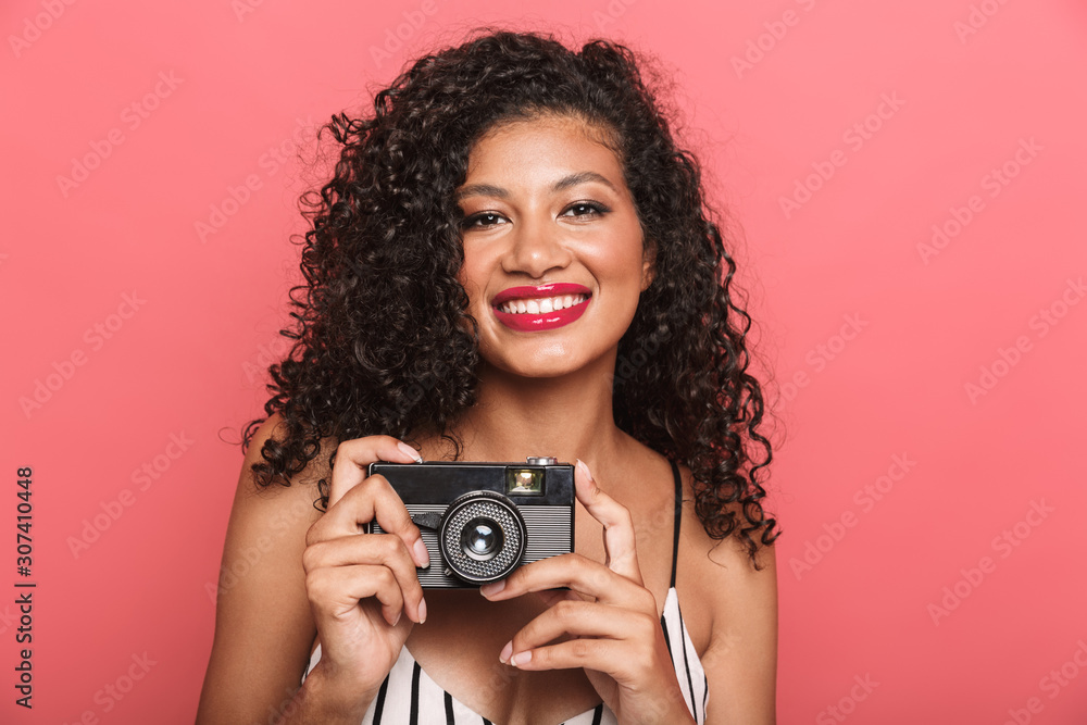 Wall mural Image of positive african american woman photographing on retro camera - Wall murals