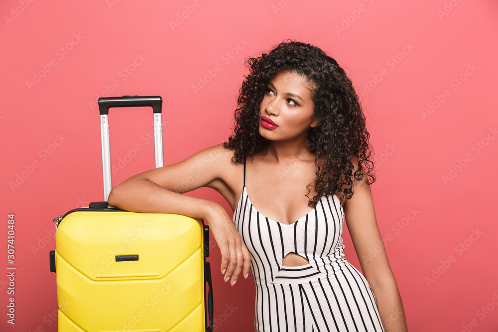 Wall mural Image of african american woman with curly hair standing by luggage - Wall murals