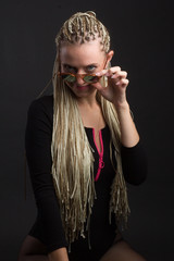 Fototapeta na wymiar Fashion shoot woman sunglasses. with a creative colorful hairstyle in the form of a pigtail braided from dreadlocks Afro-pigtails in the technique of zizi. in motion air dancing