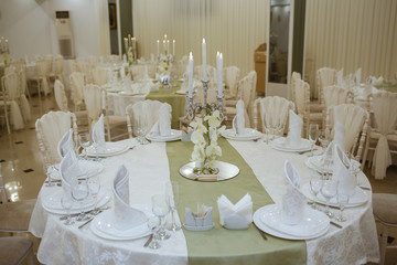 Restaurant decorated with white elements, and tables with crystal dishes.