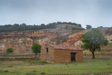  country house in a village of Castilla La Mancha, Spain, on a rainy day, with mountains background