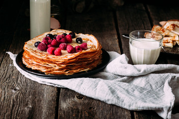 Pancakes on a plate with berries. Breakfast. Maslenitsa