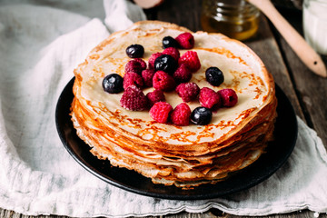 Pancakes on a plate with berries. Breakfast. Maslenitsa