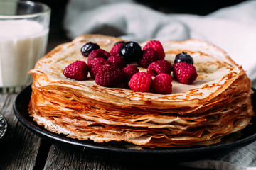 Pancakes on a plate with berries. Breakfast. Maslenitsa