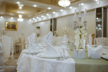 Restaurant decorated with white elements, and tables with crystal dishes.
