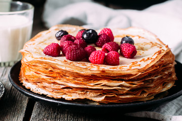 Pancakes on a plate with berries. Breakfast. Maslenitsa