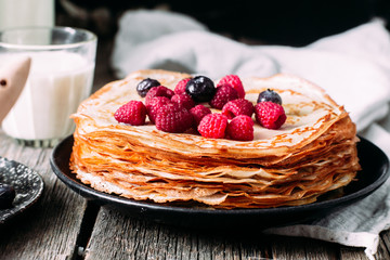 Pancakes on a plate with berries. Breakfast. Maslenitsa