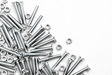 Top view of stainless steel bolts or iron nails on brigth white background with silver color. Metal...