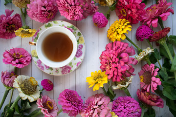 Сup of tea and flowers on wooden table.
