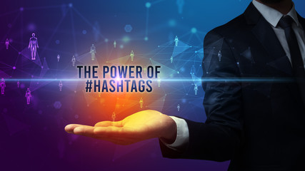 Elegant hand holding THE POWER OF #HASHTAGS inscription, social networking concept