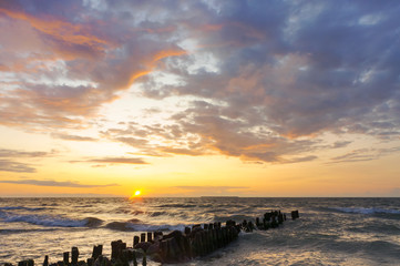 Sunset over the sea. Reflection of sunlight in the sea waves. The sky in the sunset rays.