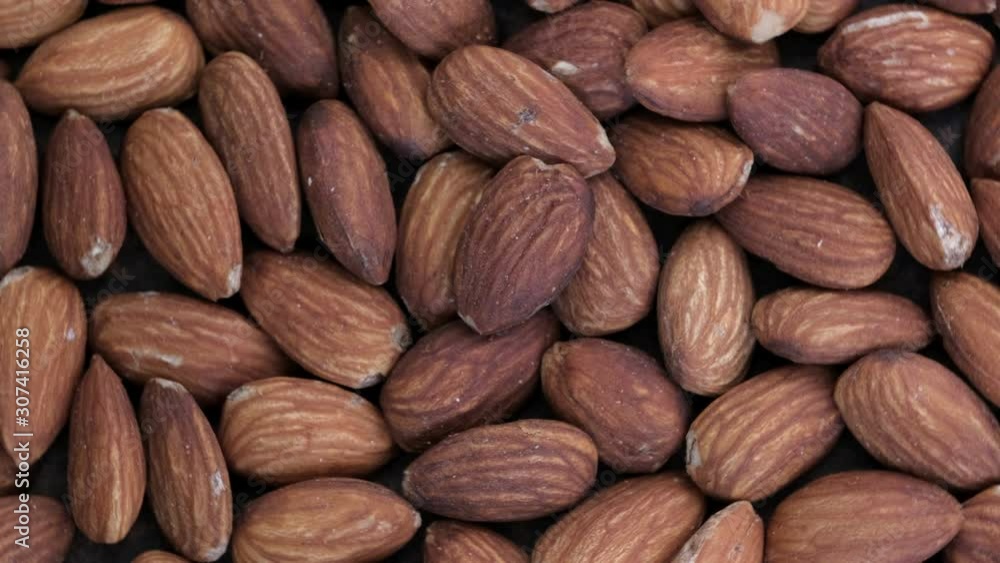 Poster grocery video screen saver, rotating background from almond kernels macro close-up top view