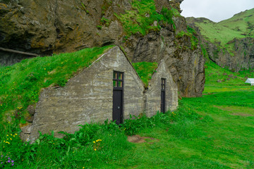 Dug in the green grass, the home of the Hobbits in Iceland. Traditional home Storage. Herbal roof. Journey around the island. The Landscape Of Iceland. Tourism.