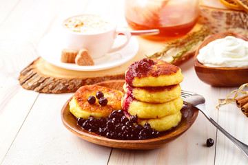 Cottage cheese pancakes and blueberries on a white wooden table, selective focus