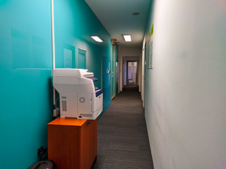 Modern hallway at work office job with laser printer available for workers for doing the paperwork and dealing with copying documents