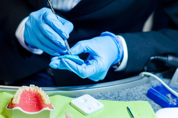 Close-up of denture manufacturing process. Tooth reconstruction.