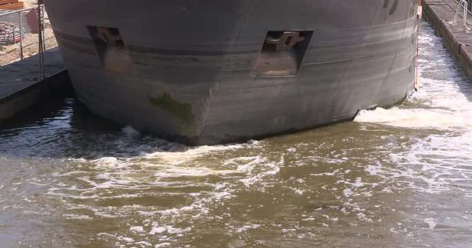 Inland ship using its maneuvering thruster in a lock pound. Note the transversal water jet.