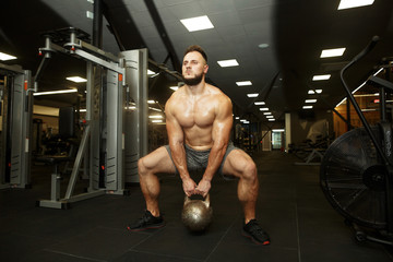 Fototapeta na wymiar Crossfit MAN training with kettlebell in gym.