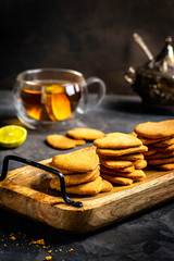 Exposition of home made biscuits and tea on black background. Tasty cake make with love. lime