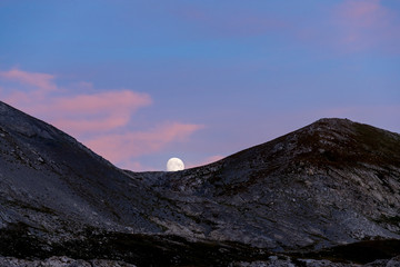 Moonrise over the Majestic Mountains at Dusk