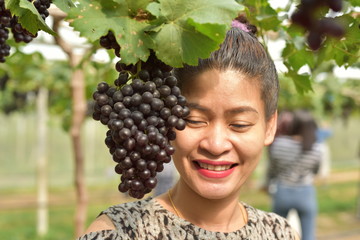 Girl with grapes in the orchard