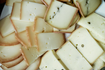 close up on slices of cheese at raclette party
