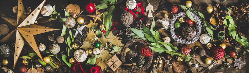 Christmas, New Year holiday layout background, texture, wallpaper. Flat-lay of decorative objects, fur tree toys, garland, ropes, candles, glass balls, wreaths over wooden background, wide composition