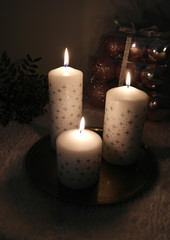 Three snowflake candles and christmas decorations