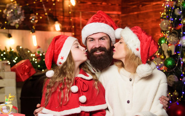 Fototapeta na wymiar Love and kindness. Caring closest people. Togetherness concept. Father Santa claus costume with family celebrating christmas. Lovely daughter with parents wearing Santa hat. Being best Santa for them