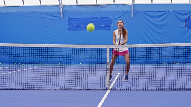 Teenage tennis athlete training with her mentor and practicing volley and crosscourt shots