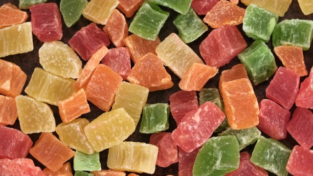 Grocery video splash, rotating background of slices of dried mango, pineapple, banana and other tropical fruits, close-up top view