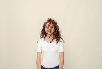 Curls of brown color fell on girl's face. Portrait of cheerful woman