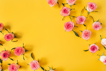 Flat lay frame border with blank copy space mockup made of pink rose flower buds on yellow background. Top view floral concept.