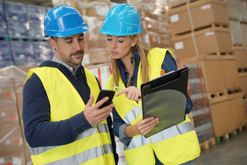 Workers in warehouse controlling incoming merchandise