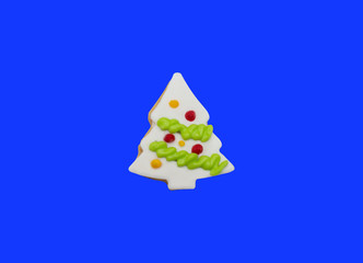 Glazed cookie in form of Christmas tree decorated with colorful frosting on blue background, top view
