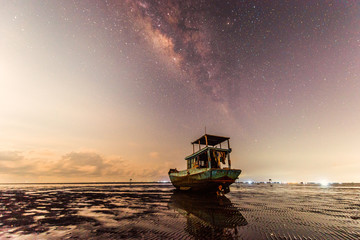 Beautiful landscape of milky way and the ship on beach
