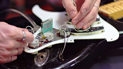 Guitar maker analyze wires inside an electric guitar