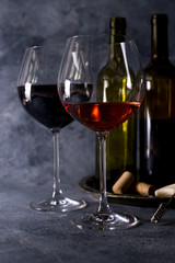 Red wine. Bottle and glass of red wine. Vintage style. Red wine on a black background. Design with space for your text.