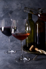Red wine. Bottle and glass of red wine. Vintage style. Red wine on a black background. Design with space for your text.