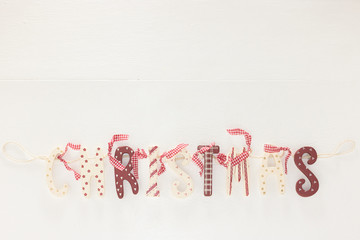 Beautiful Festive Decor Text ‘CHRISTMAS’ is on White Wooden Background, Copy Space, Banner. Top View Flat Lay Bottom Border Composition. Holiday Template, Mockup, Invitation Card. 