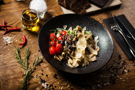 Black Angus Pasta Served In A Black Bowl In Restaurant