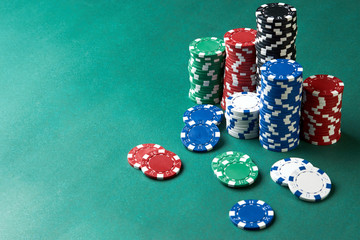 Poker gambling chips on green background with copy space.
