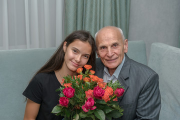 family portrait grandfather and granddaughter with colorful bouquet of roses flowers during...
