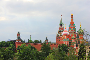 Obraz premium Moscow Kremlin tower and Saint Basil's cathedral on the Red Square in cental Moscow, Russia. Scenic russian capital architecture view, historical old city buildings on cloudy summer day 