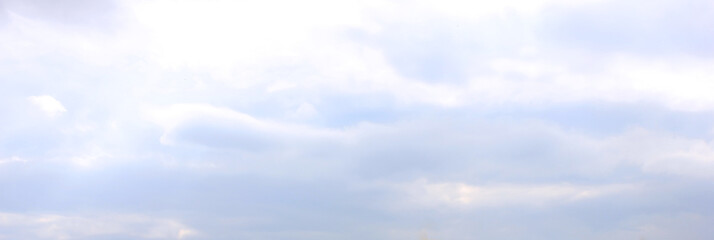 Blue sky cloudy background. Sky texture with fluffy clouds after rain, wide horizontal banner...