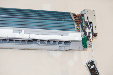 Split air conditioner closeup repair and maintenance concept. The specialist repairs the wall air conditioner. Inverter Air conditioning service