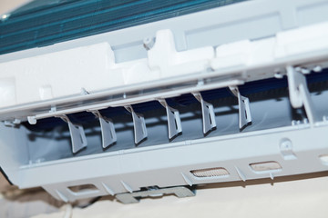 Split air conditioner closeup repair and maintenance concept. The specialist repairs the wall air...