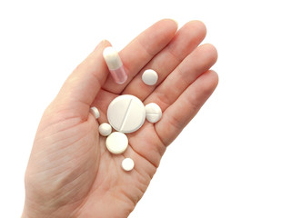 Hand with pills isolated on white background. Composition of pills and hand.